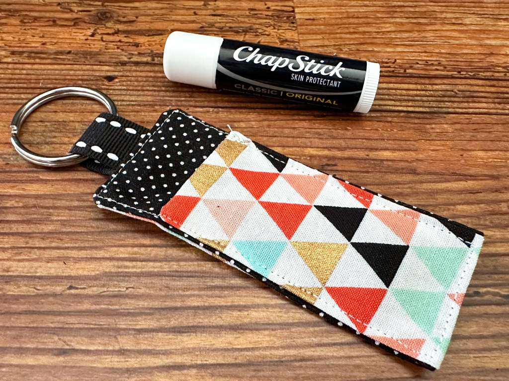 close up of a DIY fabric lip balm holder next to a tube of chapstick