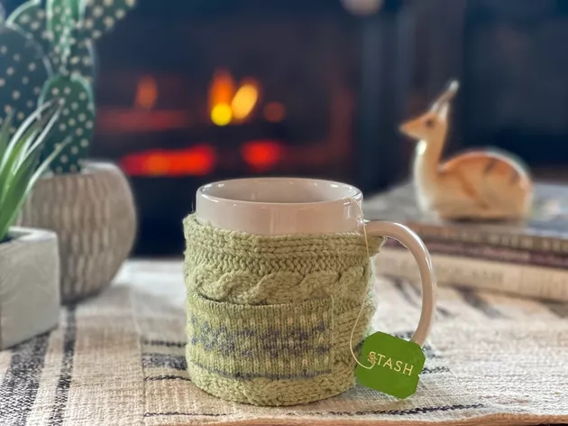 Cup and Mug Cozy made from and old sweater filled with tea by a fireplace